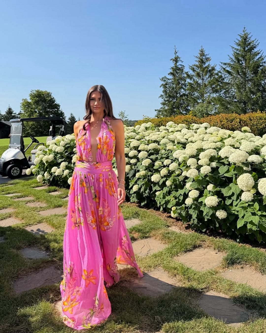Full-length front view of the same pink floral maxi dress on the model.