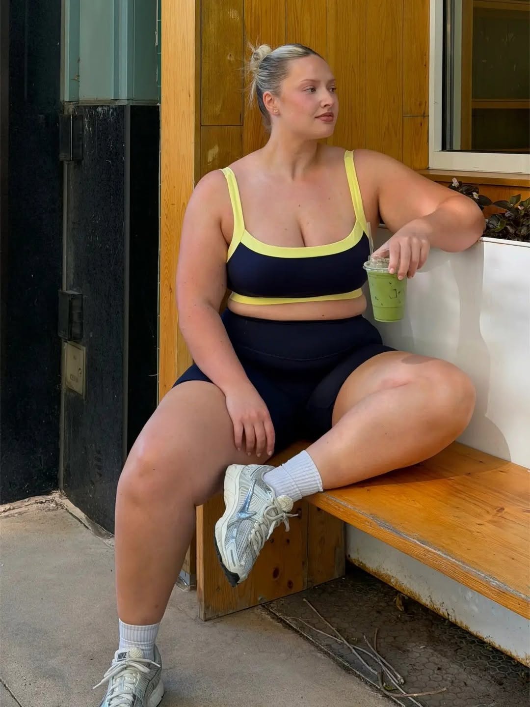 Seated pose showing the full outfit including sneakers and socks.