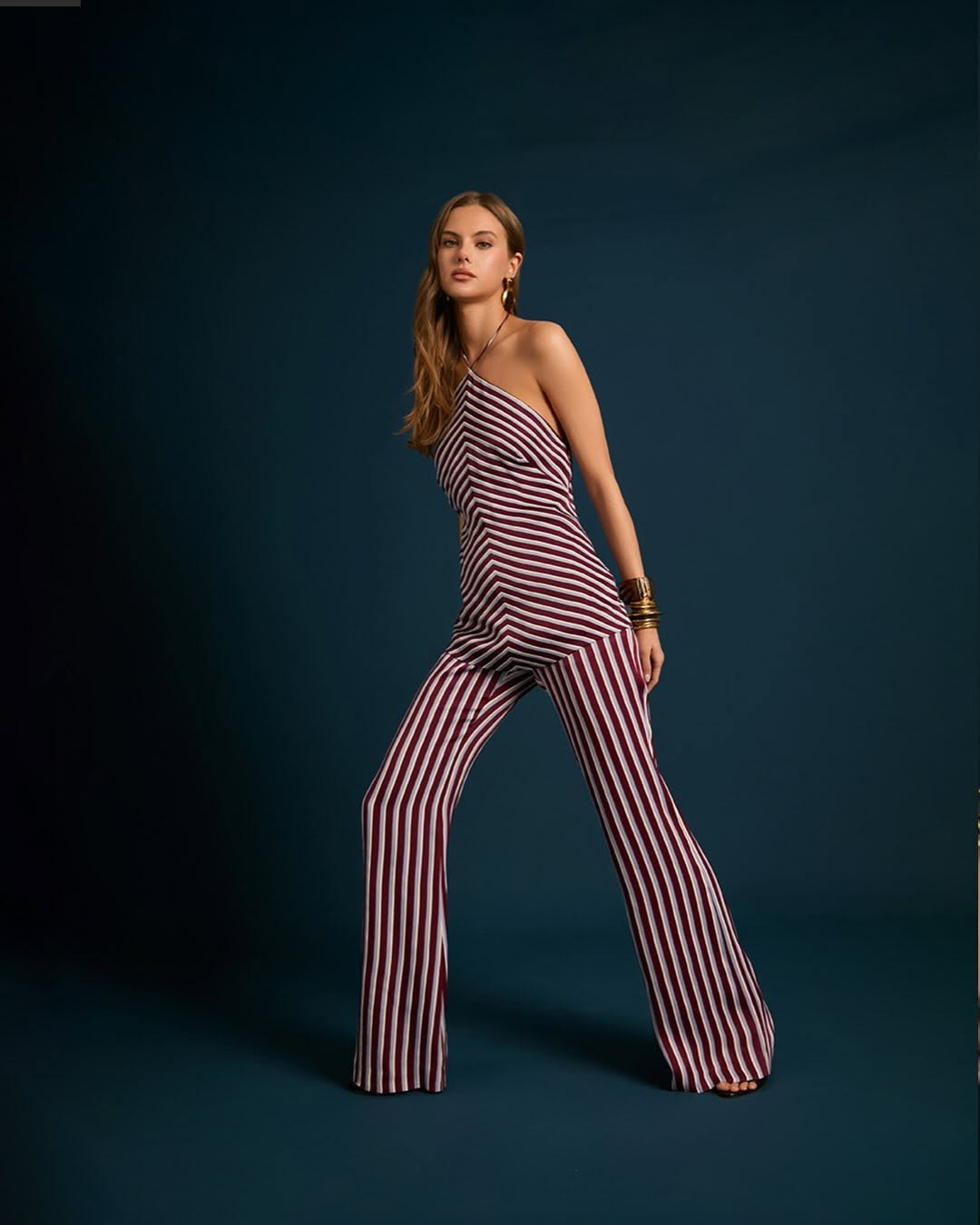 Full-body shot from a slightly different angle highlighting the drape of the fluid fabric and the fit of the trousers.