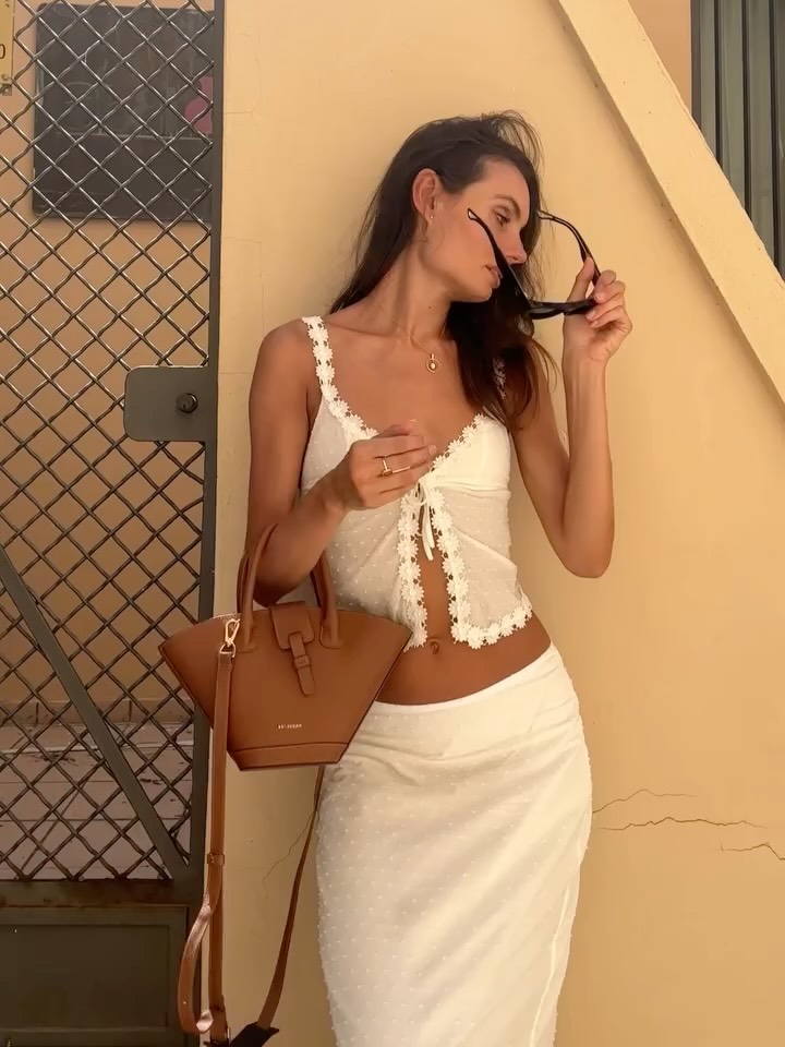 Three-quarter view showing the fit of the white crop top and textured midi skirt.