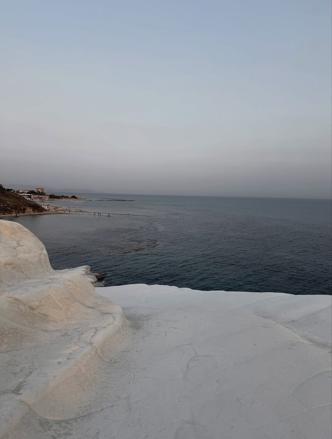 Scenic landscape shot of the sea and white rocky terrain; no fashion subject visible.