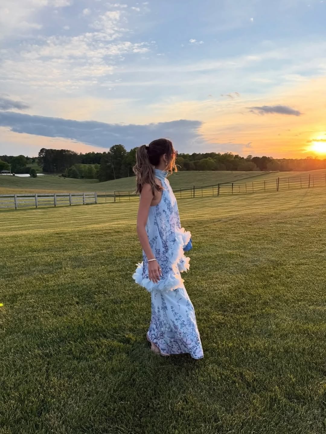 Side profile of the dress in a field, emphasizing the flowing silhouette and ruffled texture.