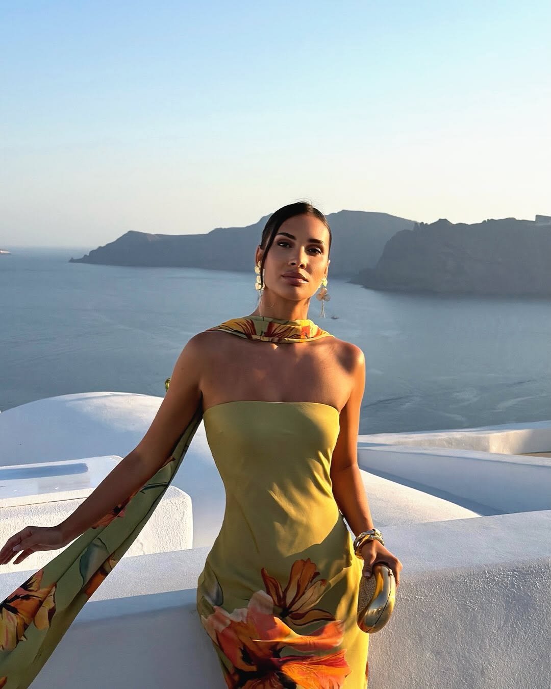 Frontal portrait of the model wearing the olive green floral dress and scarf.
