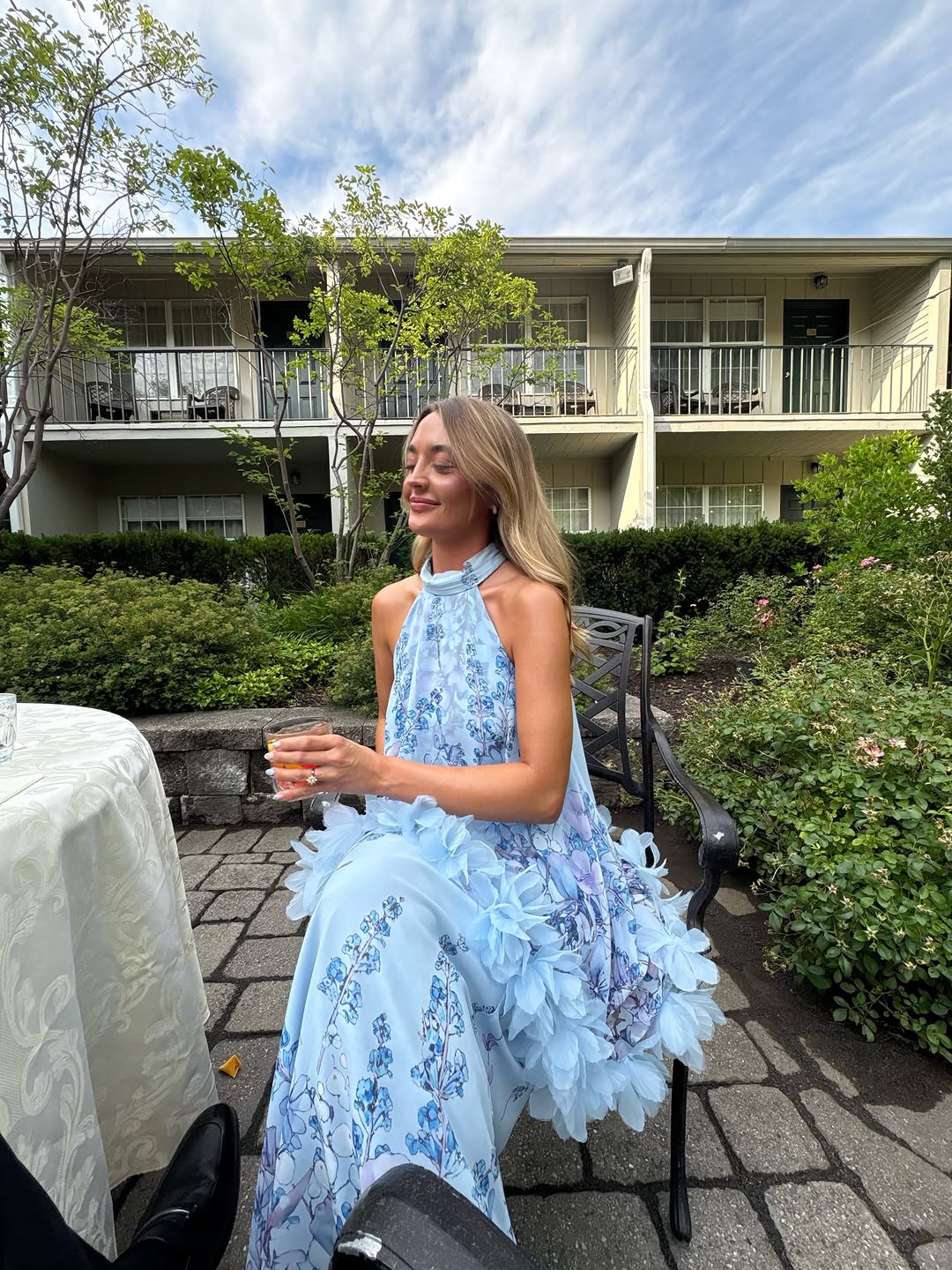 Seated view of the dress highlighting the high neckline and voluminous tulle layers over the skirt.