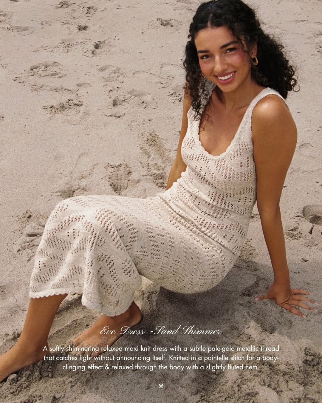 Front view of the model sitting on the beach in the textured knit dress.
