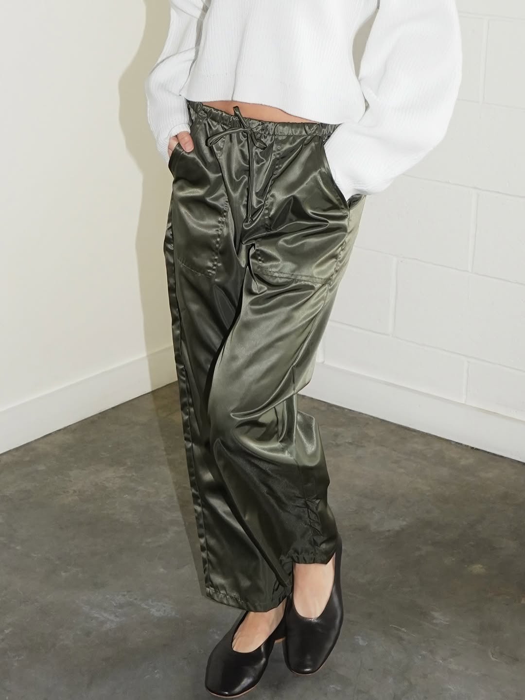 Olive green satin pants styled with a white sweater.