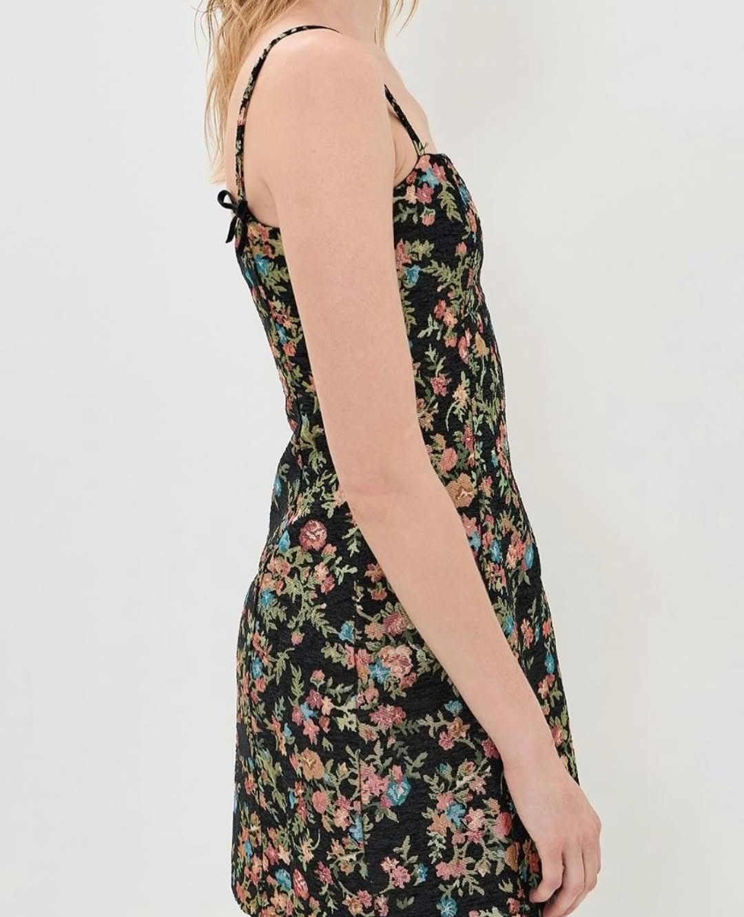 Side profile view of the model wearing the black floral tapestry dress.