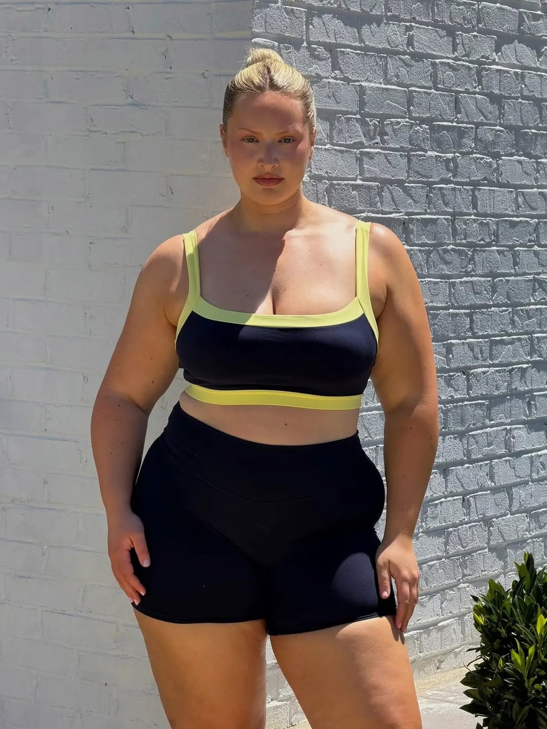 Front view of the model in the same navy and yellow activewear set.