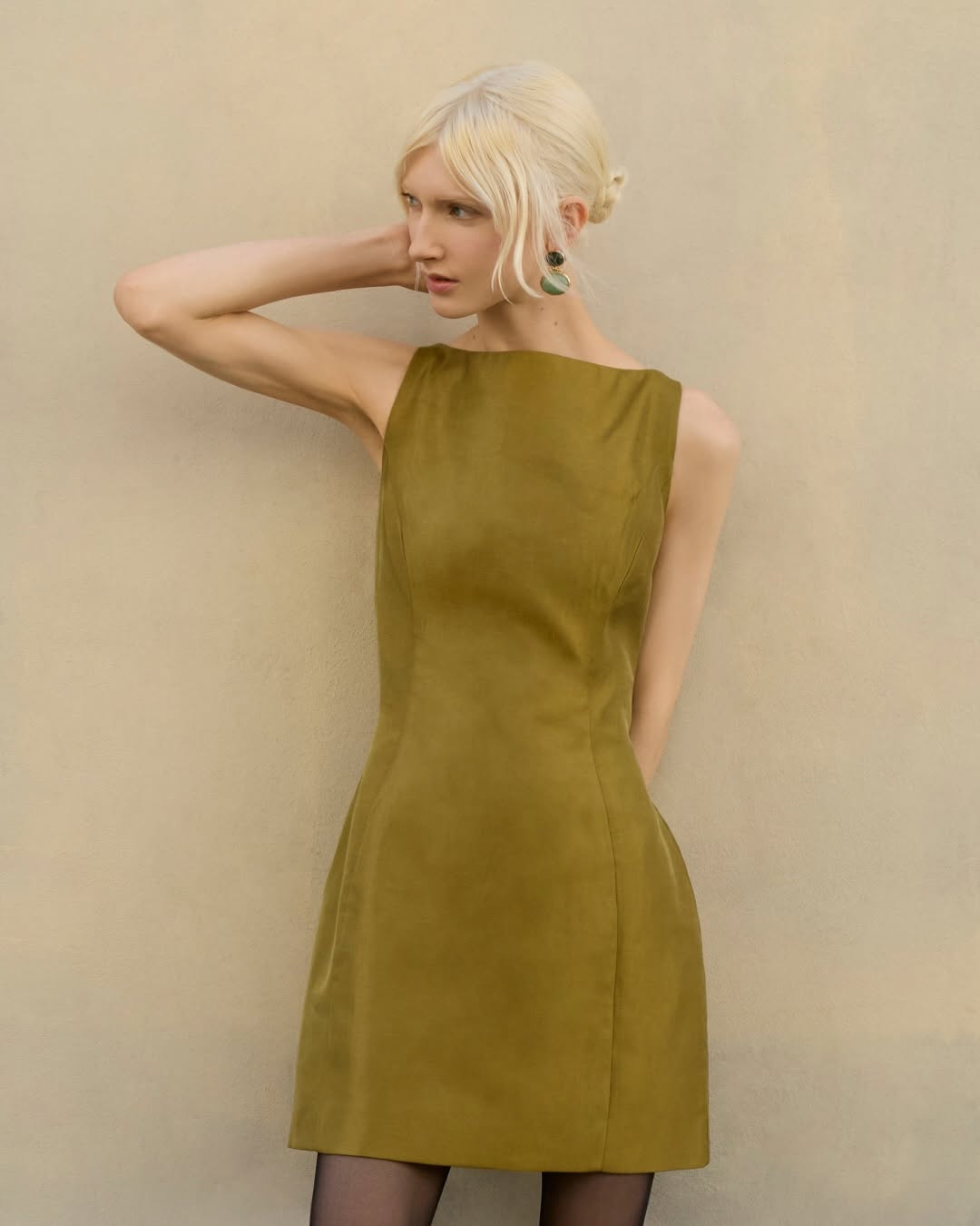 Same olive green, sleeveless mini dress shown from a slightly different angle.