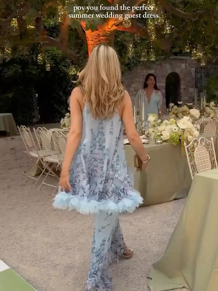 Back view of the dress featuring an open back design and cascading tiers of floral-printed tulle.