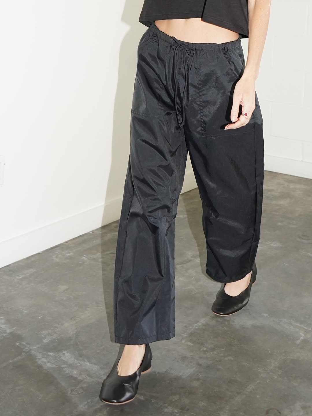 Black satin pants shown from the waist down.