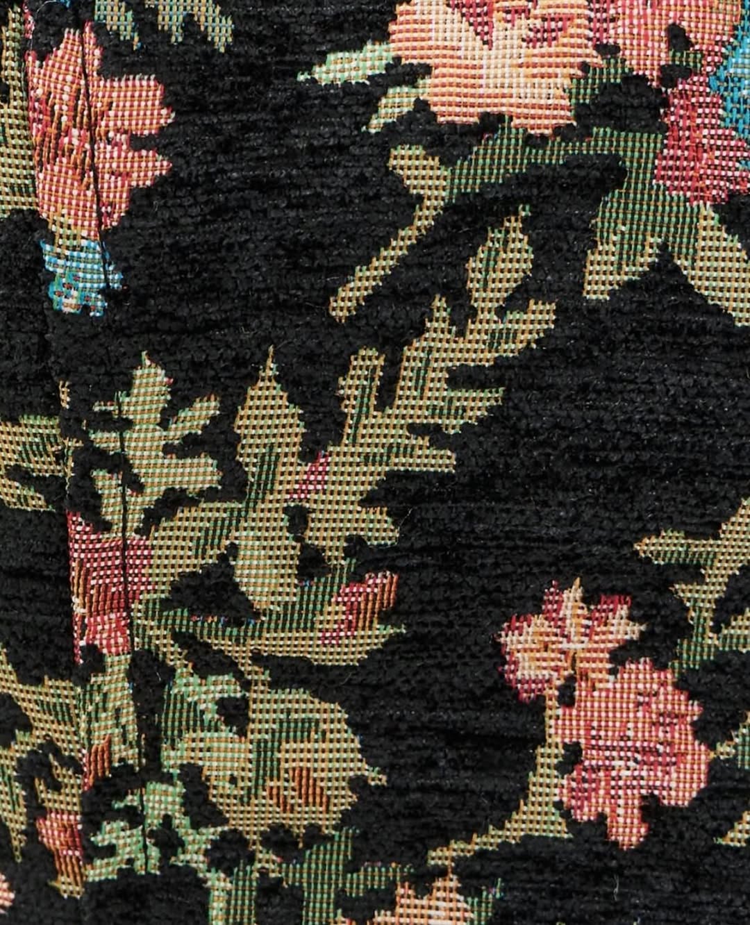 Extreme close-up of the woven texture and floral pattern of the dress fabric.