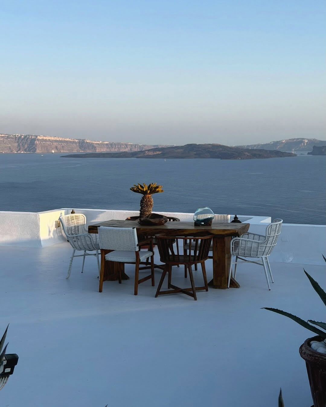 Scenic shot of a terrace dining area overlooking the sea; no fashion subject visible.