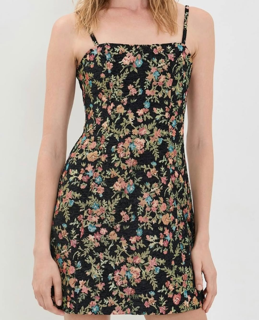 Model wearing the black floral tapestry mini dress, front torso view.