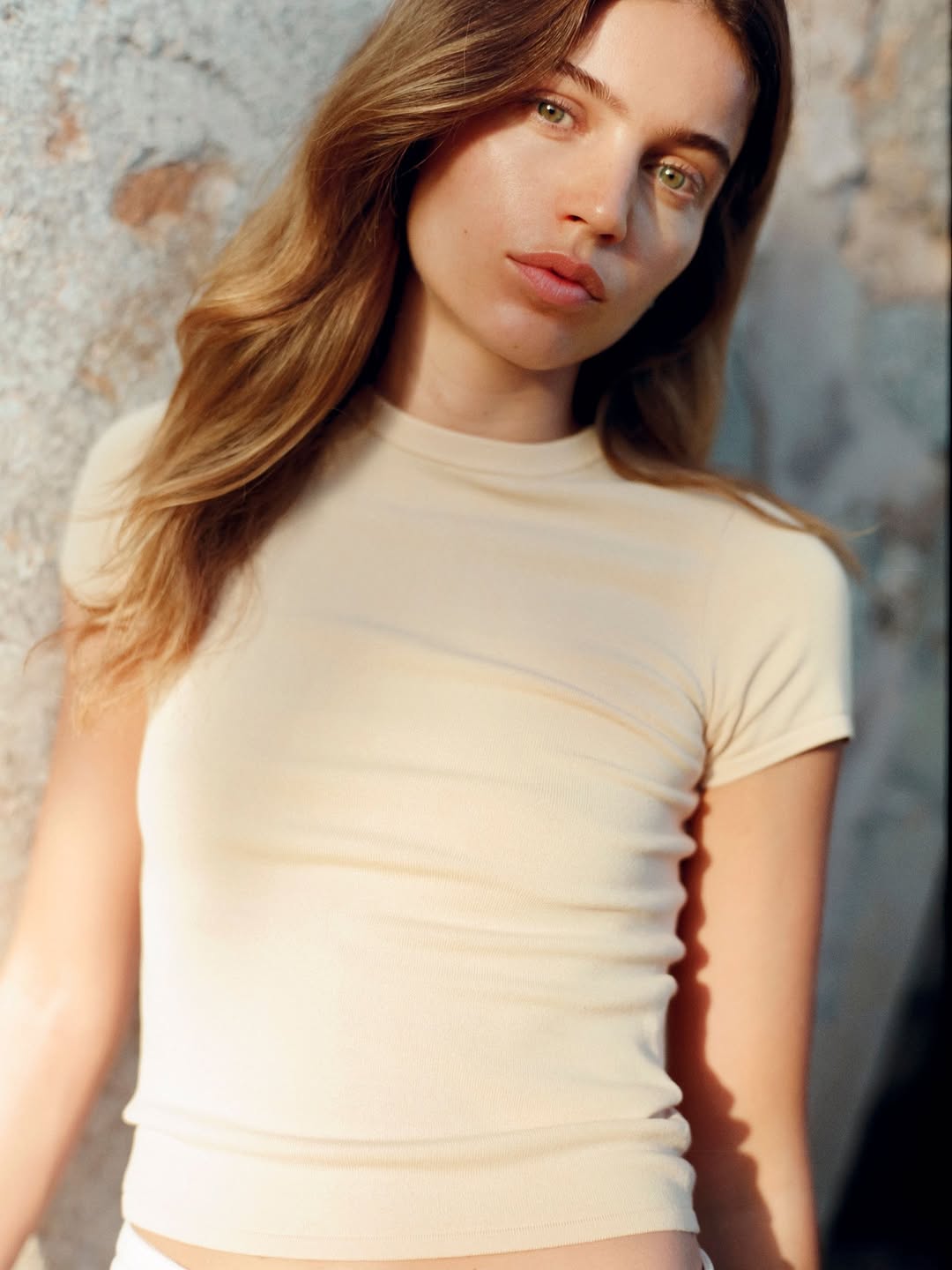 Close-up shot of the cream ribbed crew-neck t-shirt worn by the model.