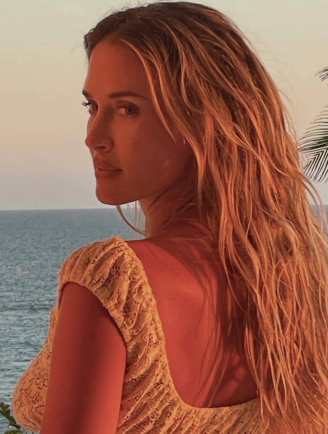 Close-up side profile of model wearing the cream lace dress.