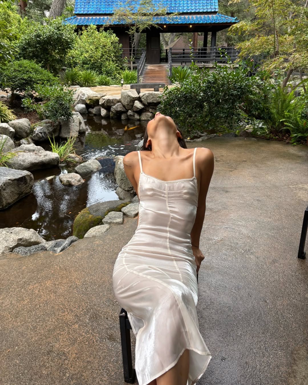 Back view of the seated model displaying the low-back design and smooth fit of the gown.